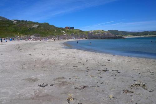 a beach with people swimming in the water at The Blue Door Apartment in Cahersiveen