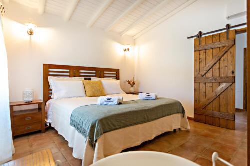 1 dormitorio con 1 cama y puerta de madera en Casa da Soalheira en São Brás de Alportel