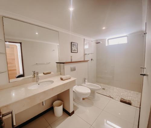 La salle de bains est pourvue d'un lavabo, de toilettes et d'un miroir. dans l'établissement Sunset Cottage, à Langebaan