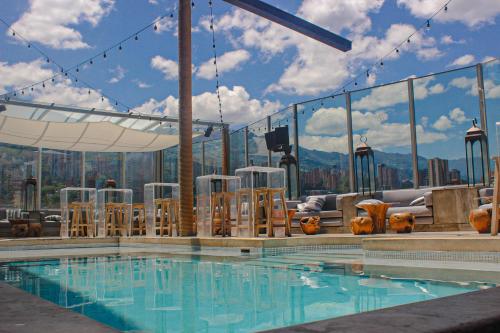 a pool with chairs and a view of the mountains at The Charlee Hotel in Medellín