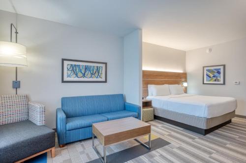 チェスターフィールドにあるHoliday Inn Express & Suites St. Louis - Chesterfield, an IHG Hotelのベッドとソファ付きのホテルルーム