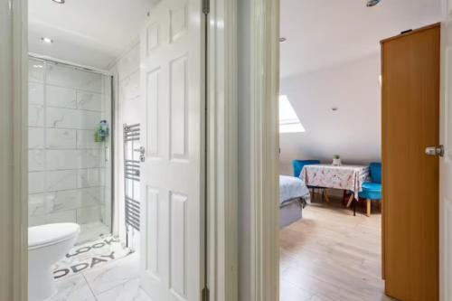 a bathroom with a shower and a toilet in a room at Comfy Friendly Stay in London