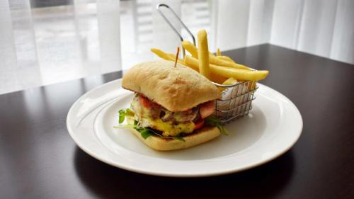 a white plate with a sandwich and french fries at Holiday Inn Parramatta by IHG in Sydney