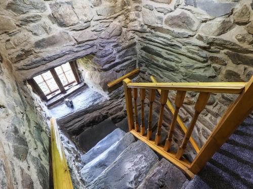 a staircase in a stone building with a window at Cwm Yr Afon Mawr in Llanbedr