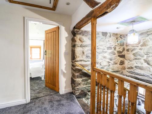 a stone staircase in a house with a stone wall at Cwm Yr Afon Mawr in Llanbedr