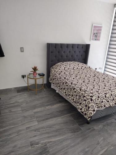 a bedroom with a bed and a table on a wooden floor at Excelente Depa en Sabalo Country in Mazatlán