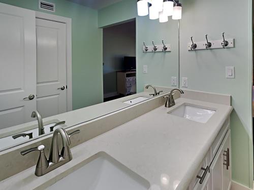 a bathroom with two sinks and a large mirror at Edgewater Villa #2406 in Panama City Beach