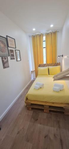 ein Schlafzimmer mit einem großen gelben Bett mit zwei Kissen in der Unterkunft S.Soares Yellow Beato in Lissabon