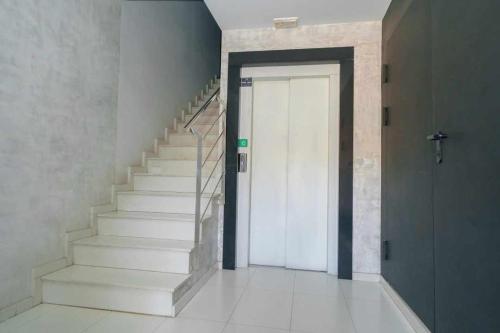 a hallway with a white staircase with a door at Apartamentos Doctor Clara in Castellón de la Plana