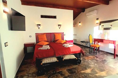 - une chambre avec un lit rouge dans l'établissement Aladin Comfort Country House, à Campinho