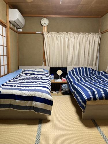 Postel nebo postele na pokoji v ubytování Guest House Hinode
