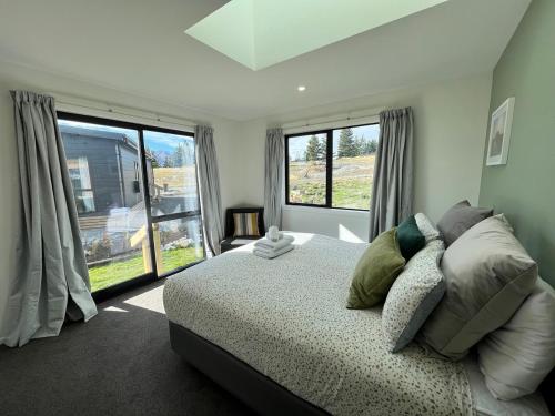 a bedroom with a bed and a large window at Nova Heights in Lake Tekapo