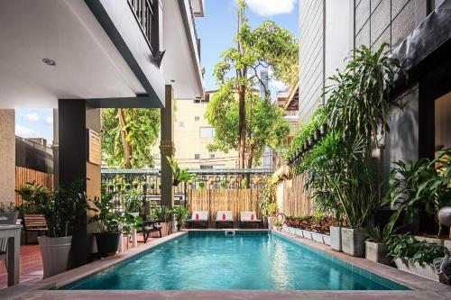 an indoor swimming pool in a building with plants at King Grand Boutique Hotel in Phnom Penh