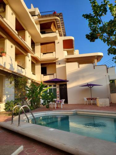 a hotel with a swimming pool in front of a building at Casa Puerto Bonito, Aparthotel & Coworking in Puerto Escondido