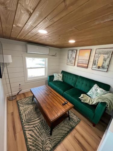 a living room with a green couch and a table at Tiny Islands Resort in Blanco