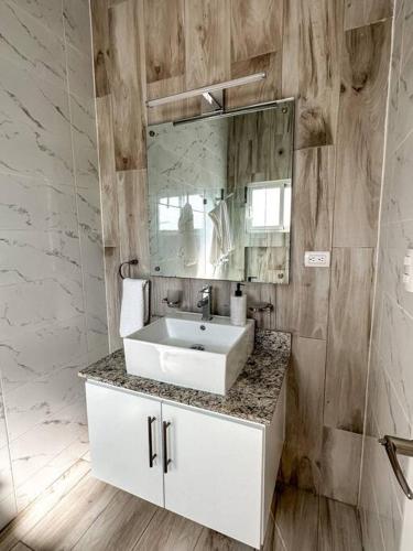 a bathroom with a white sink and a mirror at Villa Saule in Bombita