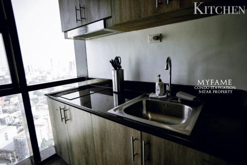 eine Küche mit einem Waschbecken und einem großen Fenster in der Unterkunft 2BR SMDC Premium Unit: FAME Residences 31st FLOOR in Manila
