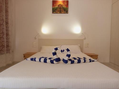a bed with a blue and white towel on it at Cassiopeia Nest in Arambol