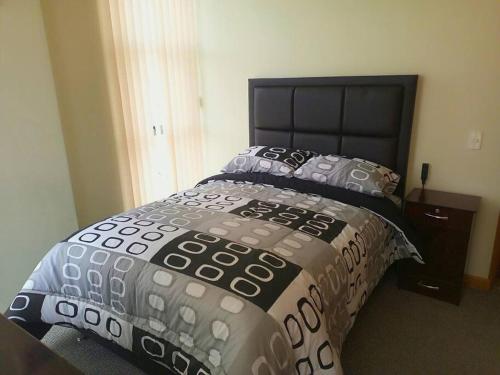a bedroom with a bed with a black headboard and pillows at Apartamento en La Paz in La Paz