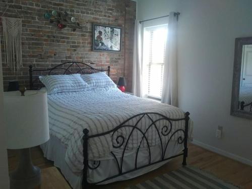ein Schlafzimmer mit einem Bett und einer Ziegelwand in der Unterkunft The Whitney in Buffalo
