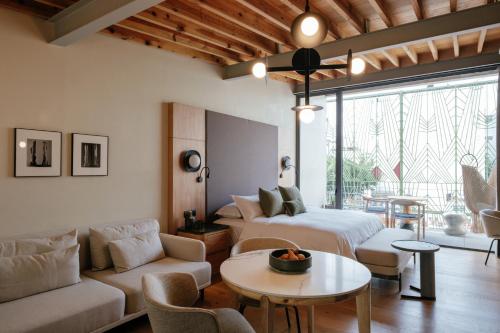 a living room with a couch and a table at Colima 71 - Casa de Arte Hotel in Mexico City