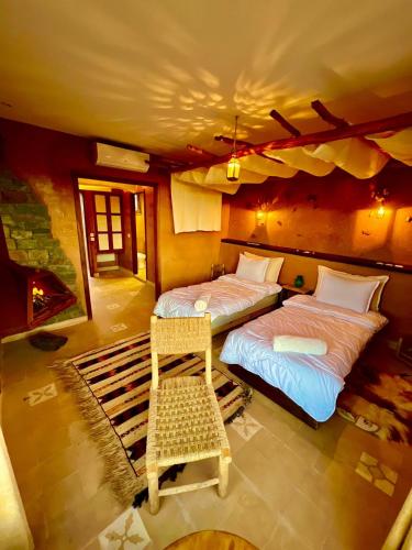 two beds in a room with a fireplace at Bin Jbal Resort in Ouirgane