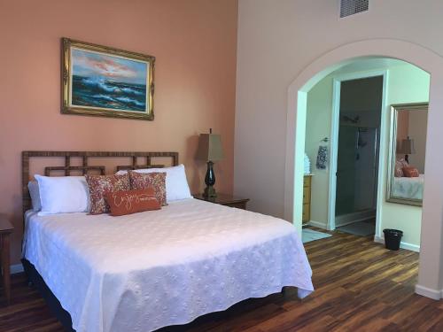 ein Schlafzimmer mit einem weißen Bett und einem Gemälde an der Wand in der Unterkunft The Best 3bd 3ba Condo Near Ocean with AC Office and Loft ACJ1 in Kailua-Kona