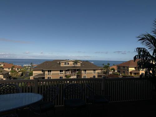 a balcony with tables and chairs and a view of the ocean at The Best 3bd 3ba Condo Near Ocean with AC Office and Loft ACJ1 in Kailua-Kona