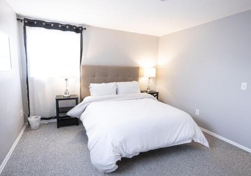 a bedroom with a white bed and a window at Cheerful home with free parking and WiFi in Rochester