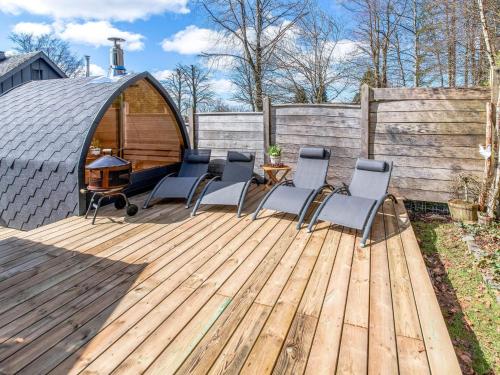 una terraza de madera con sillas y cenador en Charming house with sauna and Nordic bath en Bullange
