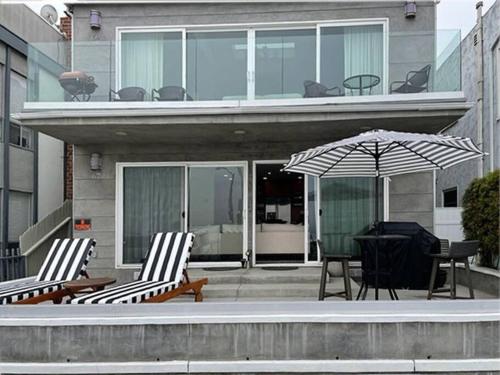 een huis met twee stoelen en een tafel en een paraplu bij Touch of Heaven in Long Beach