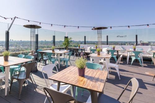 a patio with tables and chairs on a roof at Leonardo Hotel Amsterdam Rembrandtpark in Amsterdam