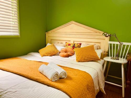 um quarto verde com uma cama grande e toalhas em Central Located 4BR Home with Rumpus & King Bed in the Heart of Melbourne em Chadstone