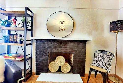 a living room with a fireplace with a mirror at Central Parkside 5BR Home with Rumpus & King Bed in Chadstone