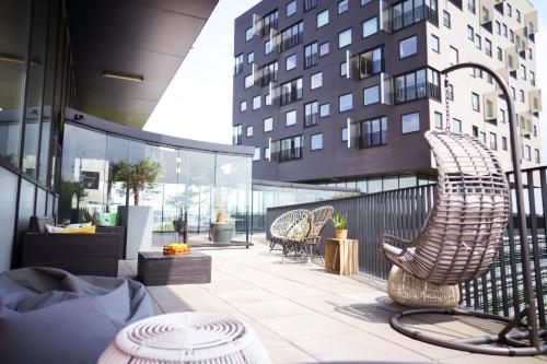 a patio with chairs and tables and a building at Leonardo Hotel Groningen in Groningen