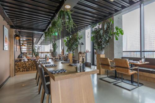 a restaurant with a bar with chairs and plants at Leonardo Hotel Groningen in Groningen