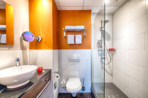 a bathroom with a toilet sink and a shower at Leonardo Hotel Amsterdam City Center in Amsterdam