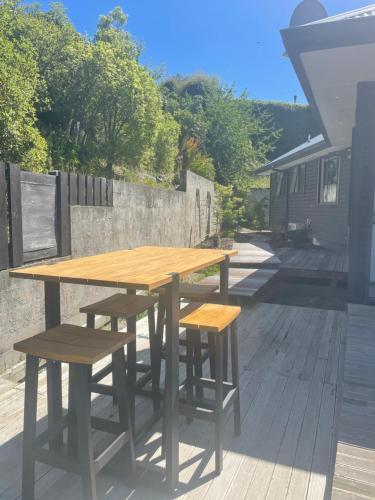 een houten tafel en banken op een patio bij Private Retreat Central Wanaka 2 Bedroom in Wanaka