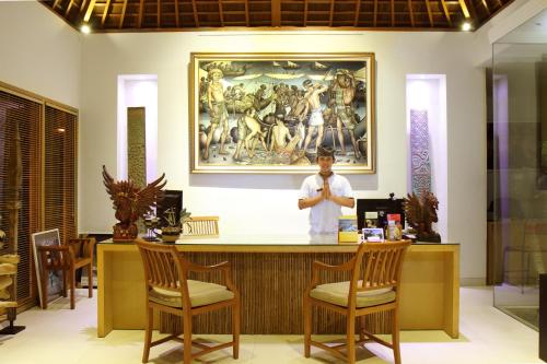 a man standing at a bar in a salon at Villa Bali Asri Batubelig in Seminyak