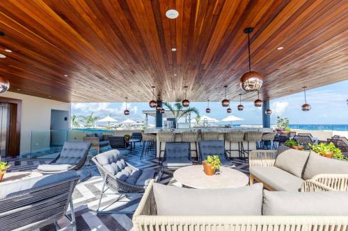 un hall ouvert avec des canapés et un bar dans l'établissement Singular by Andiani Travel, à Playa del Carmen