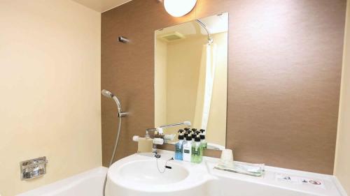 a bathroom with a sink and a mirror at Urban Hotel Kyoto in Kyoto