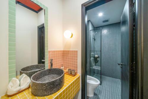 2 wastafels in een badkamer met een douche en een toilet bij BÁNH INN in Hue