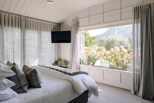 a bedroom with a bed and a large window at Craggy Range Luxury Vineyard Retreat in Havelock North