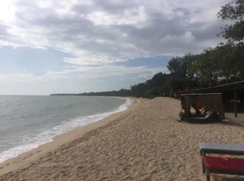 a sandy beach with a tent and the ocean at Lotus Desaru Beach Resort, 2 bdrms, w/splash park in Bandar Penawar