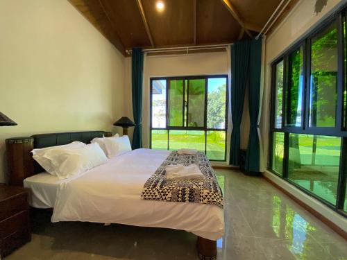 1 dormitorio con 1 cama con sábanas blancas y ventanas en coral coast FIJI, en Sigatoka