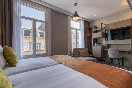 a bedroom with a large bed with a large window at Leonardo Boutique Museumhotel in Amsterdam