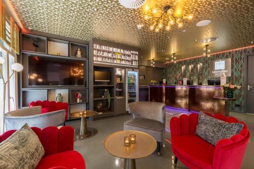 a bar with red chairs and tables in a room at Leonardo Boutique Museumhotel in Amsterdam