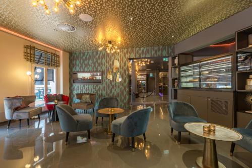 a restaurant with chairs and tables and a chandelier at Leonardo Boutique Museumhotel in Amsterdam