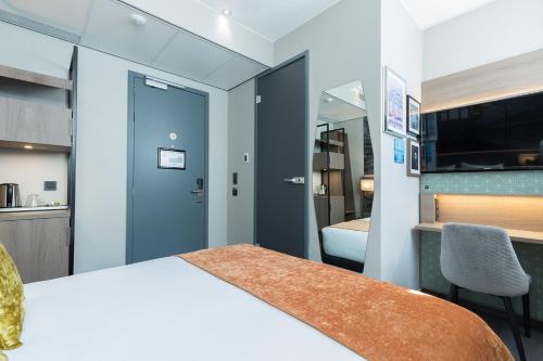 a room with a bed and a desk and a tv at Leonardo Boutique Museumhotel in Amsterdam