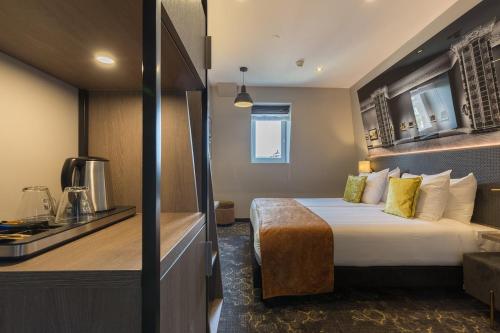 a hotel room with a bed and a kitchen at Leonardo Boutique Museumhotel in Amsterdam